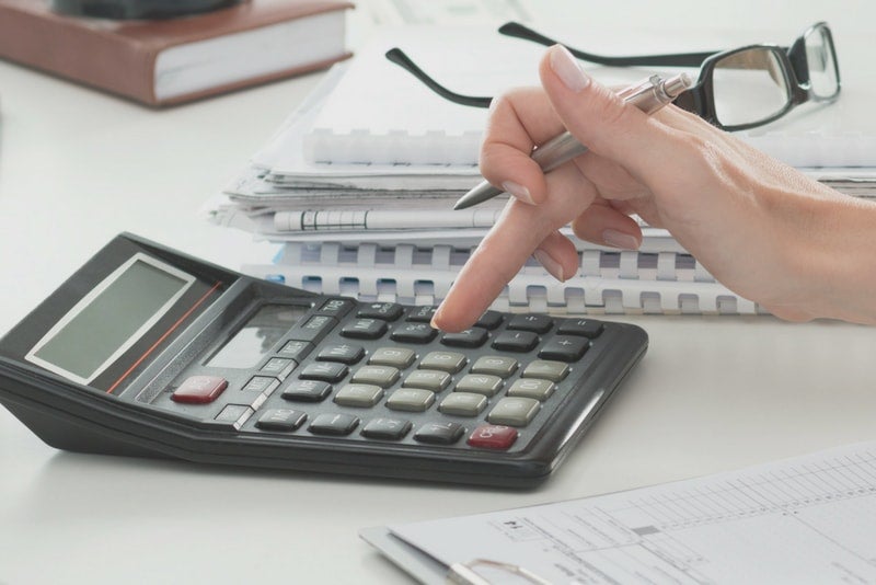Hand typing on a calculator