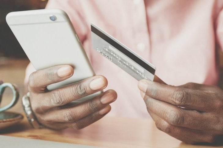 Man holding a credit card and a phone