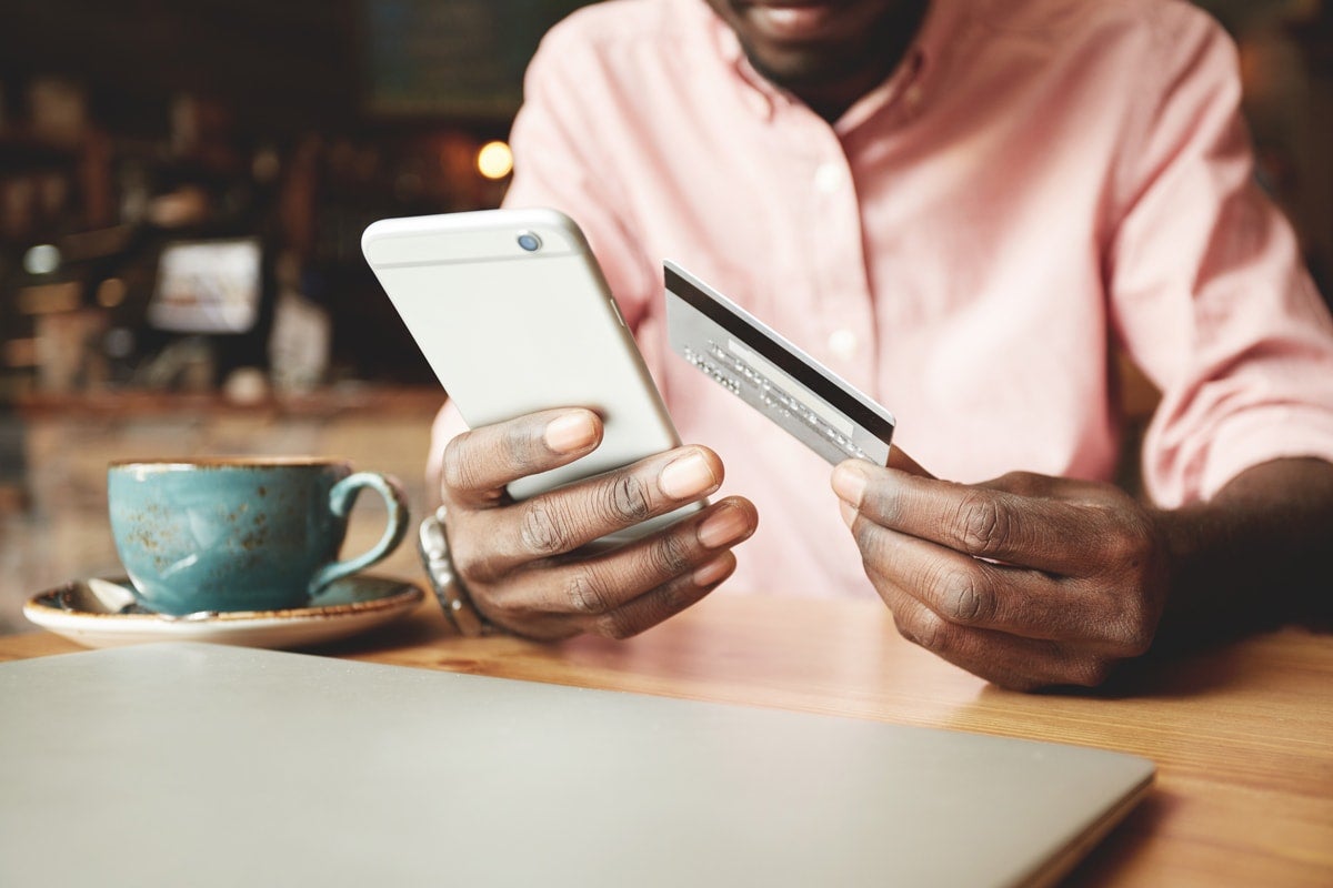 Man holding a credit card and a phone