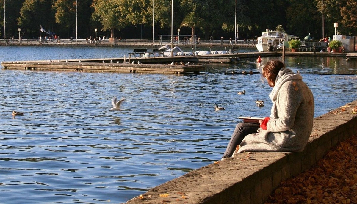 Medical resident taking a break in local park and reviewing messages on cellphone.