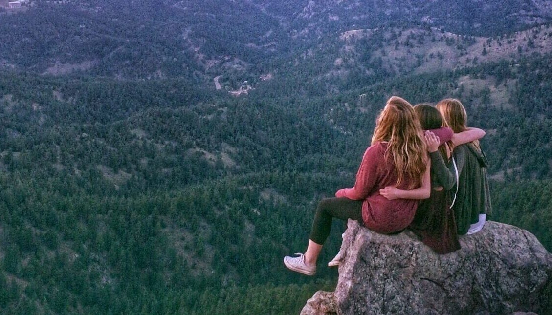 Friends on a mountain talking and enjoying the view while discussing attending college and find the right fit.