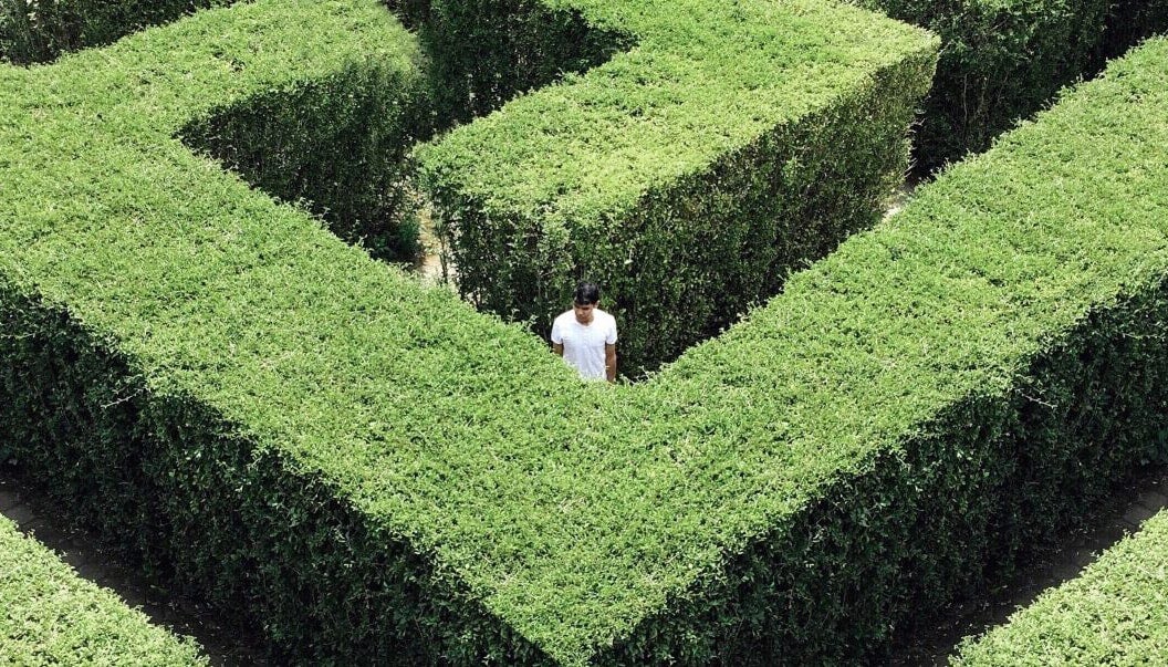 Someone confused and lost in a maze. Like choosing whether to invest or pay down student loan debt.