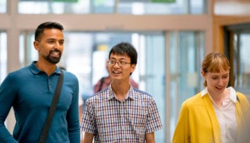 Adult students walking in collegehall