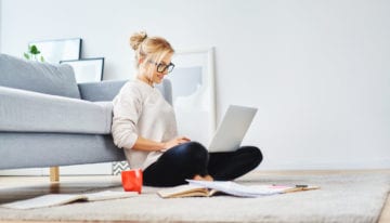 Woman sitting on floor looking at laptop computer