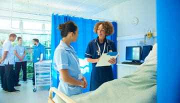 Female medical student standing next to professor