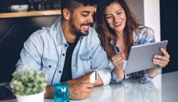 Couple sitting at table on the computer