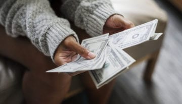 Closeup of graduated college student counting money