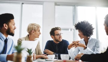 group of MBA students discussing student loan refinancing