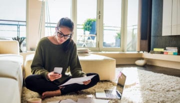 Young woman reading student loan news