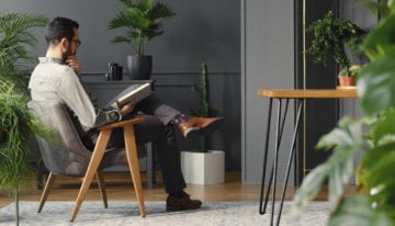 HENRY reading book at home, relaxing after achieving debt-life balance