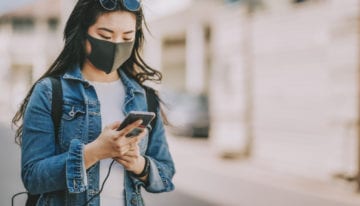 Woman checking her finances while wearing mask due to COVID-19
