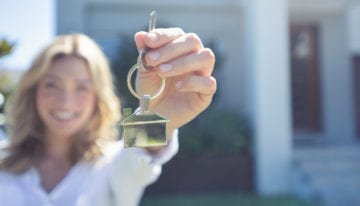 Young woman holding keys to first home