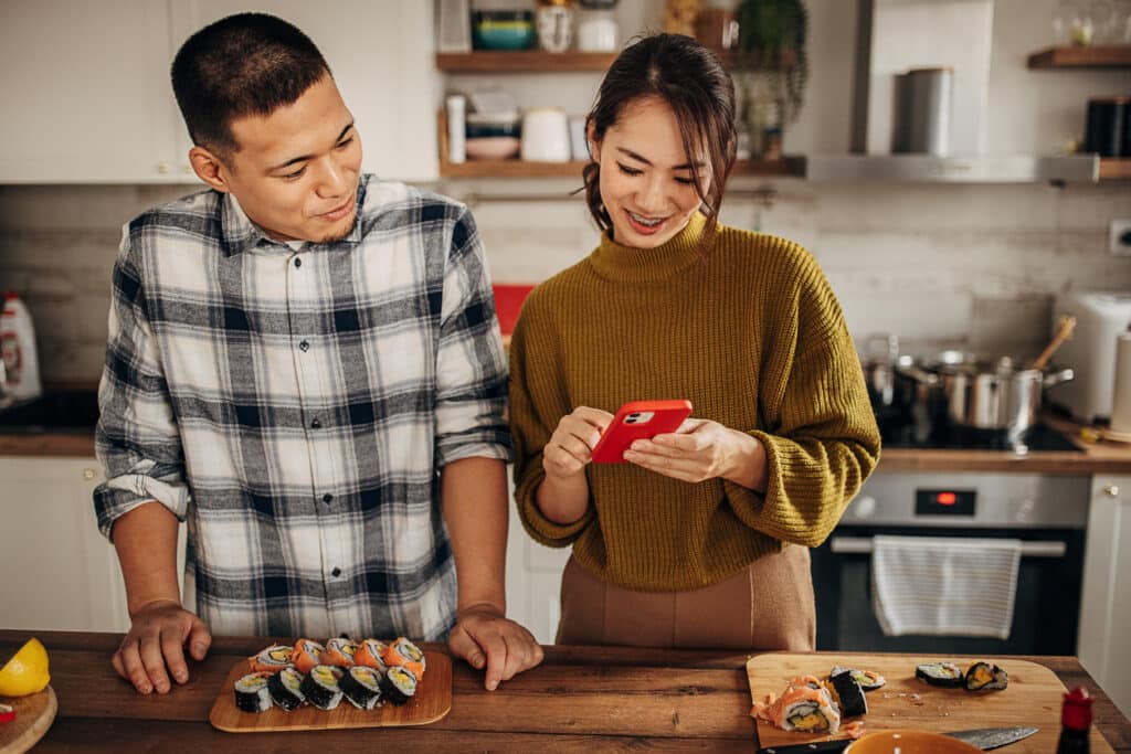 Two people, modern Japanese couple prepared sushi together in kitchen at home.