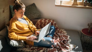 young woman researching student loan refinancing requirements