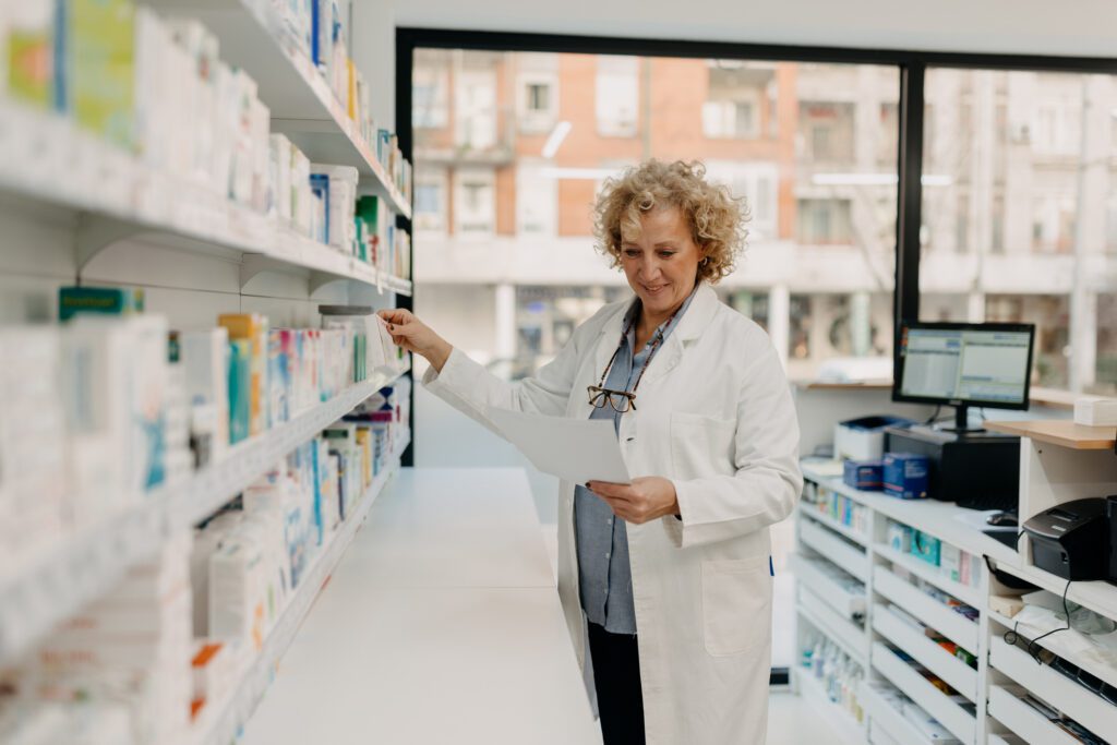 Mid-adult pharmacist reviewing inventory