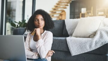 Woman thinking about using credit card to pay down student loans
