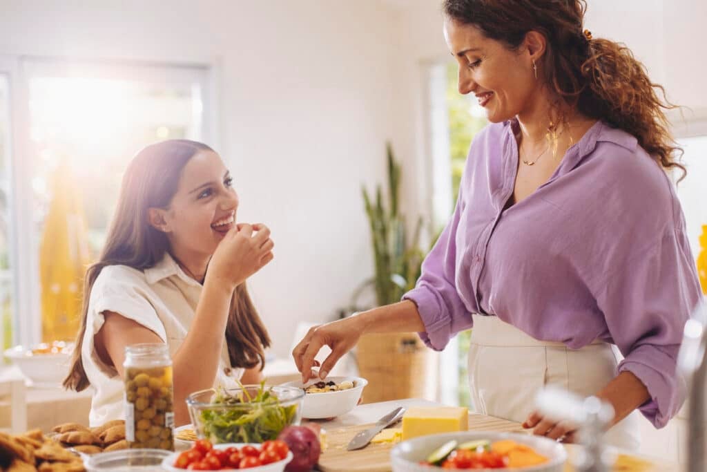 A mother and her daughter share time cooking in the kitchen