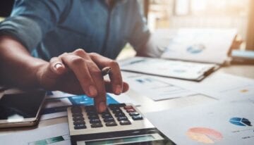 Man calculating student loan tax deductions and write-offs