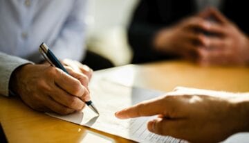 Cosigner signing student loan paperwork