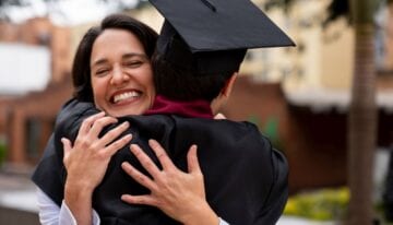 Parent hugging son at college graduation