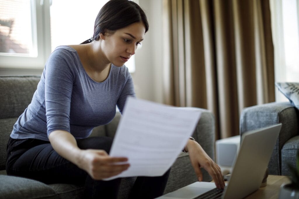Woman reviewing credit report for delinquent student loans