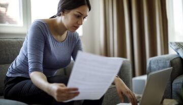 Woman reviewing credit report for delinquent student loans