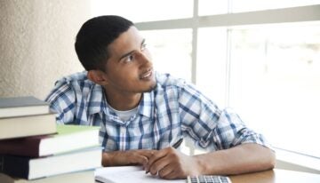 Young man considering whether student loans are worth it