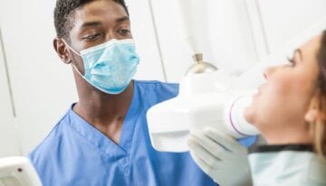 Dental school student working with patient
