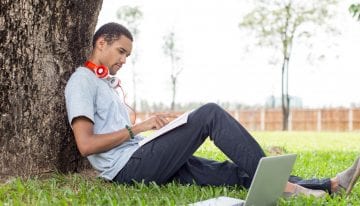 man student sitting under tree