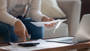 person with computer and bills