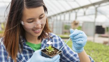 asian female college student working in greenhouse