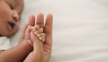 Person holding hands with a baby