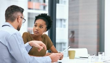 Two colleagues working together weighing the pros and cons