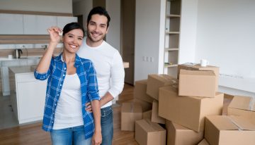 young couple holding keys to new house