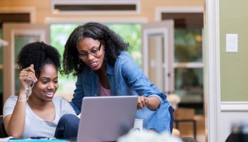 Mom and daughter reading private and federal student loan eligibility requirements