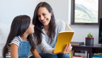 Mom reading a book to her adopted daughter