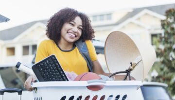 Young african american woman moving in to apartment for college