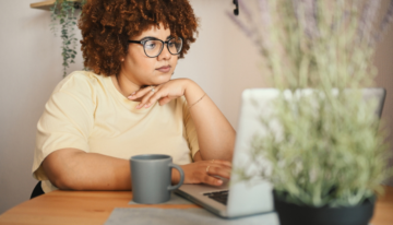 Young black woman looking at her laptop.