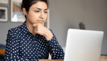 Woman looking thoughtfully at her computer.