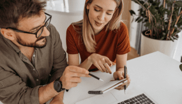 Husband and wife going over the pros and cons of paying off student loans early.