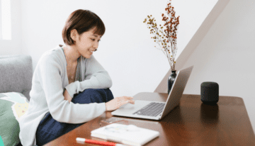 Young asian woman sitting at her desk with a laptop.