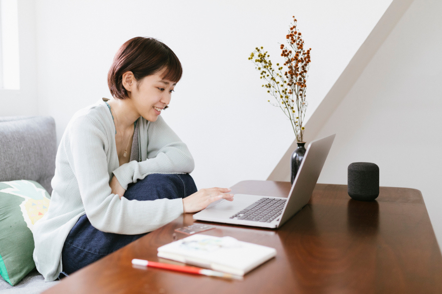 Young asian woman sitting at her desk with a laptop.