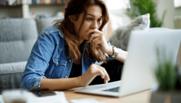 Worried female college student sitting a her laptop.