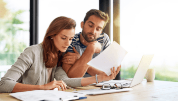 Married couple looking over student loan paperwork.