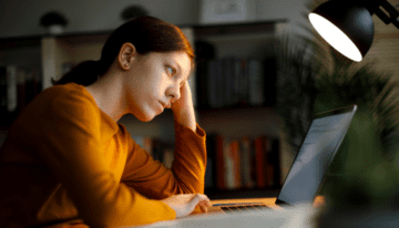 Financially stressed college student sits at her desk.