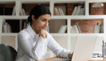 Woman sitting looking serious at her laptop.