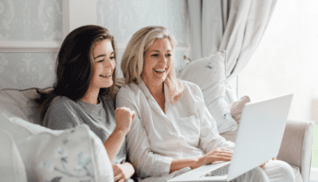 Mother and daughter looking at parent plus loan forgiveness on the computer.
