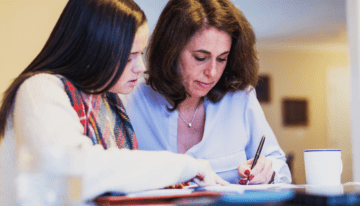 Mother and daughter looking over refinancing student loan with cosigner.