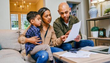 Young parents with son looking over budget to see how much to save for college.