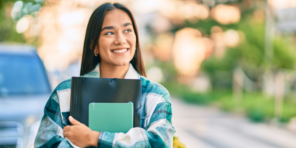 Young hispanic female college student standing on campus.